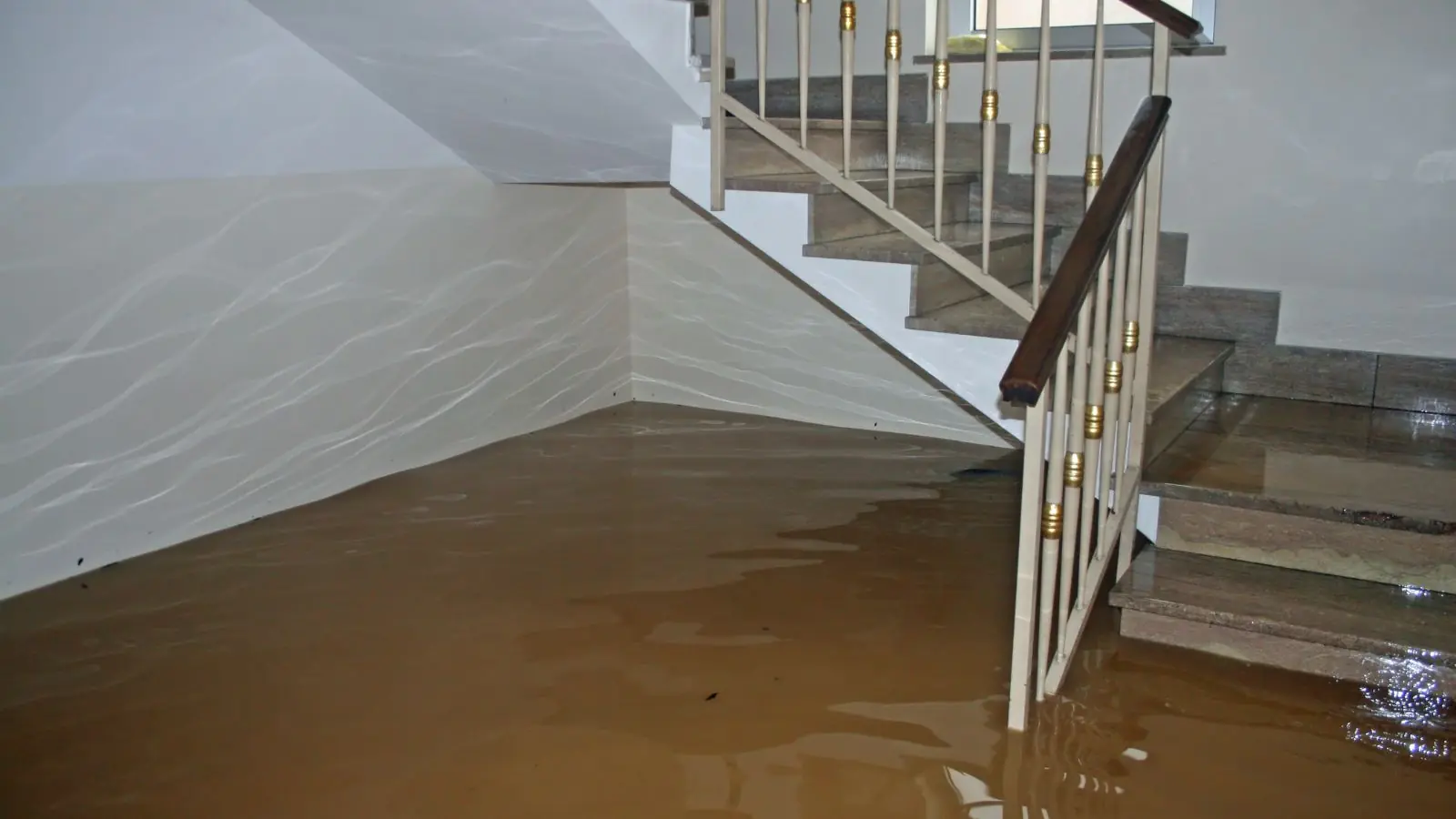 Floodwater covering the floor at the bottom of a basement staircase